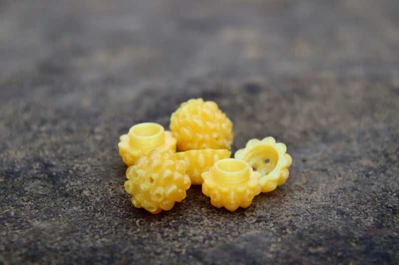 Load image into Gallery viewer, Yellow Steelhead beads, with a scent chamber siting on a rock