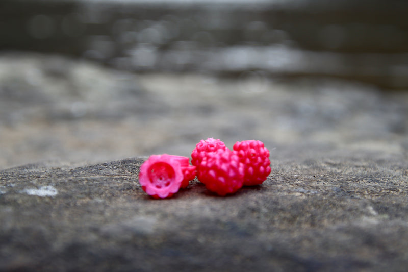Load image into Gallery viewer, Pink Steelhead beads, with a scent chamber siting on a rock
