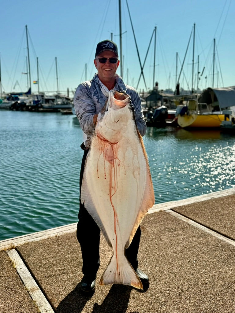Load image into Gallery viewer, man holding large halibut on a dock
